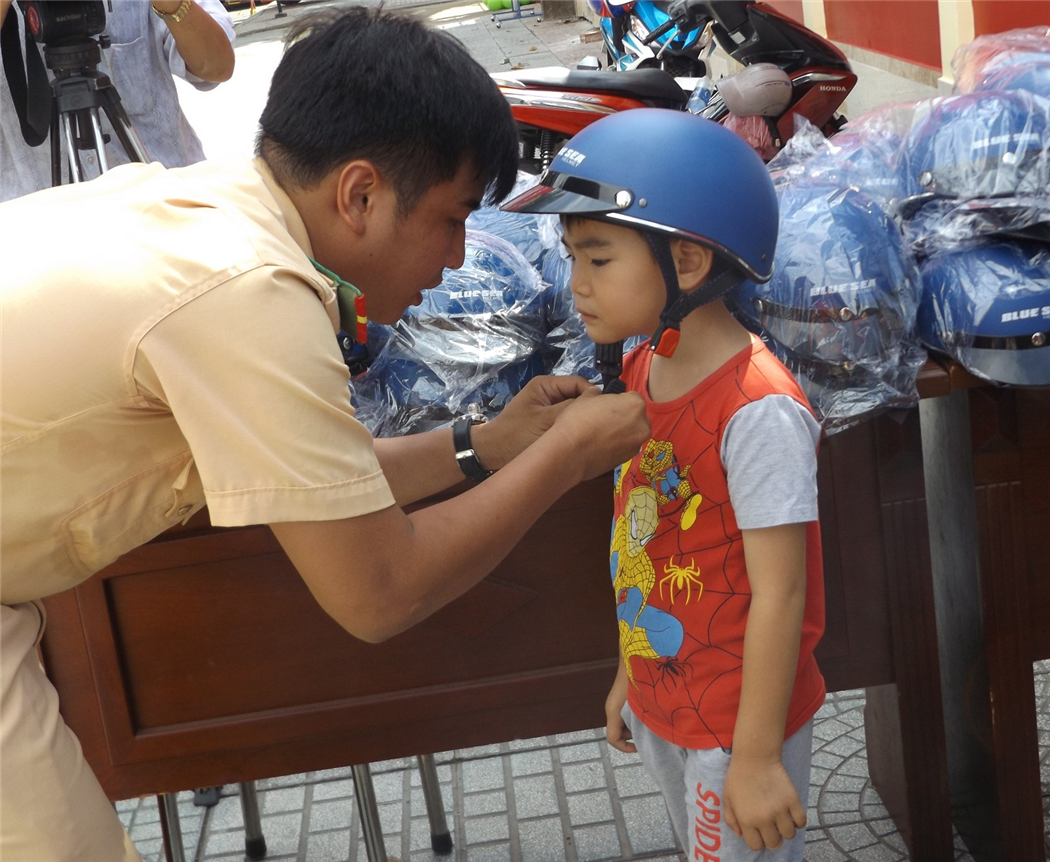 CSGT Công an TP. Hồ Chí Minh trao mũ bảo hiểm đạt chuẩn tặng phụ huynh và trẻ nhỏ trước khi bước vào năm học mới 2018 - 2019.