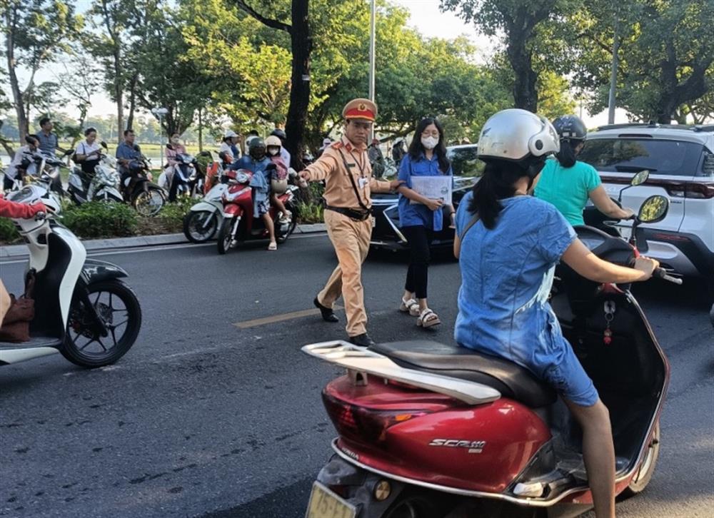 Sĩ tử được cán bộ Đội CSGT – Trật tự Công an thành phố Huế, tỉnh Thừa Thiên Huế dẫn qua đường vào điểm thi.
