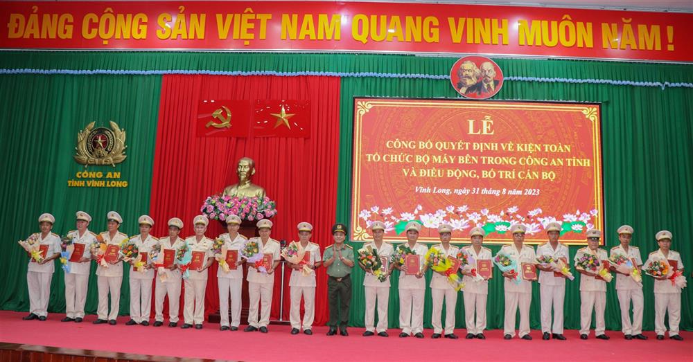 Đại tá Nguyễn Trọng Dũng, Bí thư Đảng ủy, Giám đốc Công an tỉnh Vĩnh Long trao quyết định điều động và tặng hoa chúc mừng các đồng chí lãnh đạo chỉ huy cấp Phòng và tương đương.