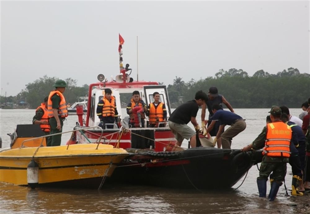 Các lực lượng đưa thi thể nạn nhân lên bờ.