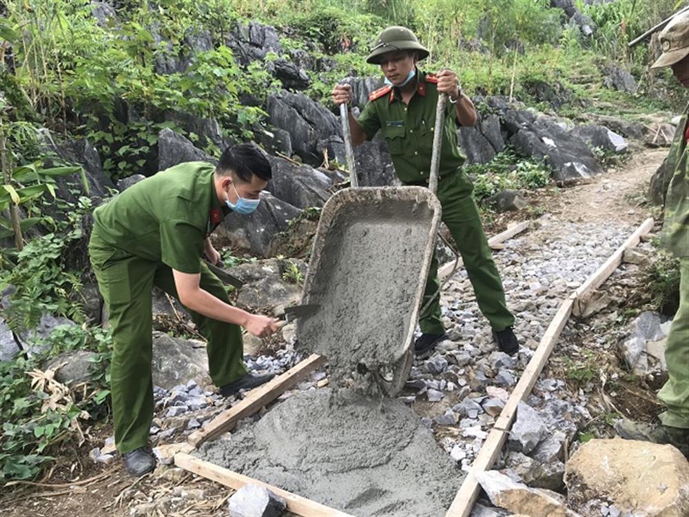 Đại úy Nguyễn Hồng Quân và cán bộ, chiến sỹ Công an xã góp sức cùng bà con nhân dân làm đường bê tông nội thôn Mã Pì Lèng, xã Pải Lủng.