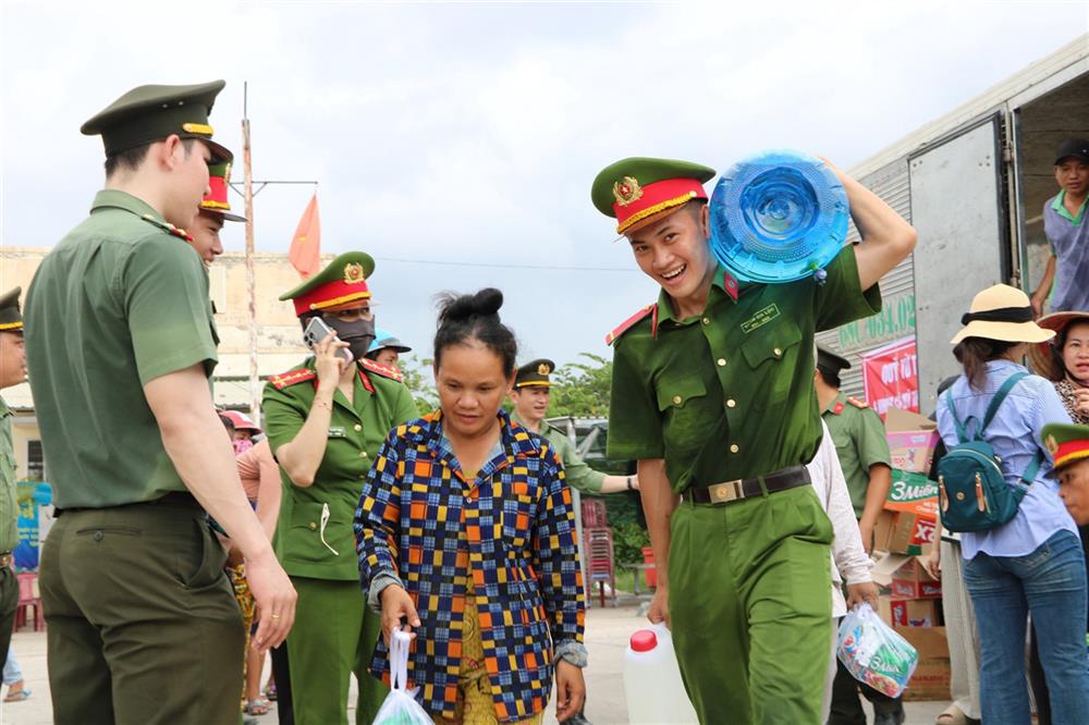 Cán bộ chiến sỹ Công an trao nước ngọt và nhu yếu phẩm tặng bà con nhân dân ở một số xã biên giới huyện Giang Thành.