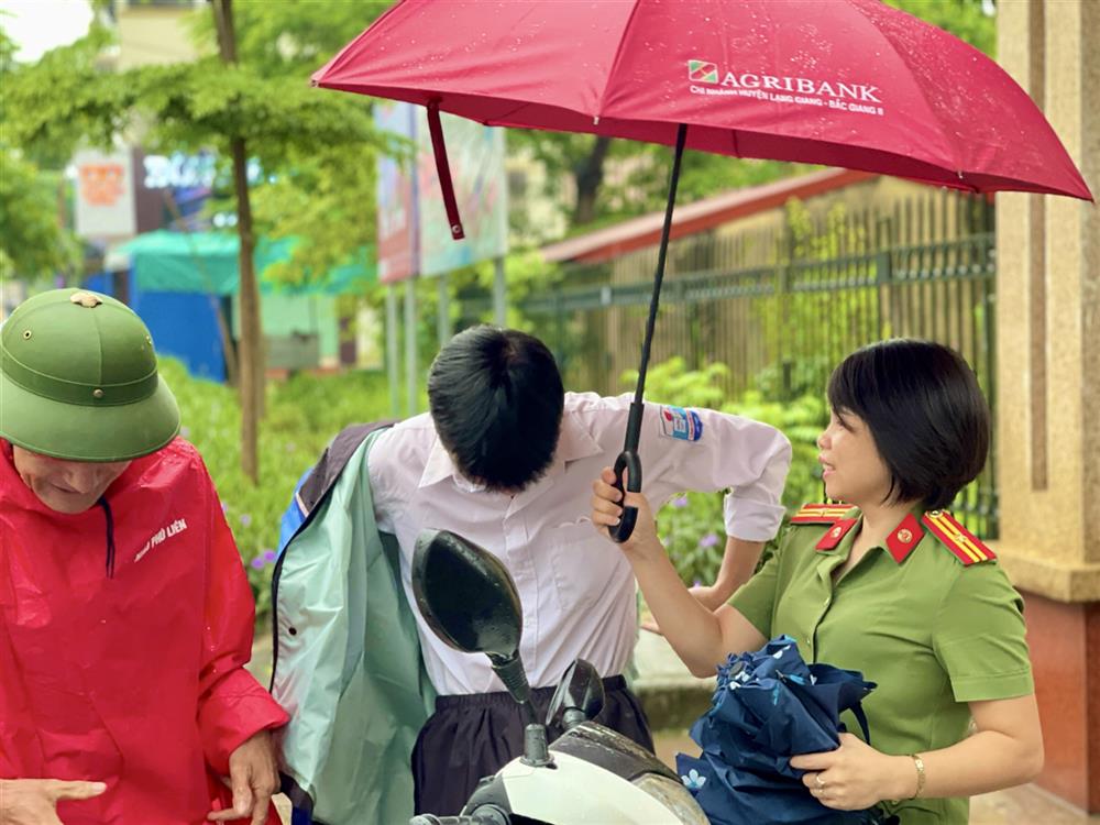 Hội viên phụ nữ Công an huyện Lạng Giang phát nước uống cho thí sinh trước khi vào phòng thi.