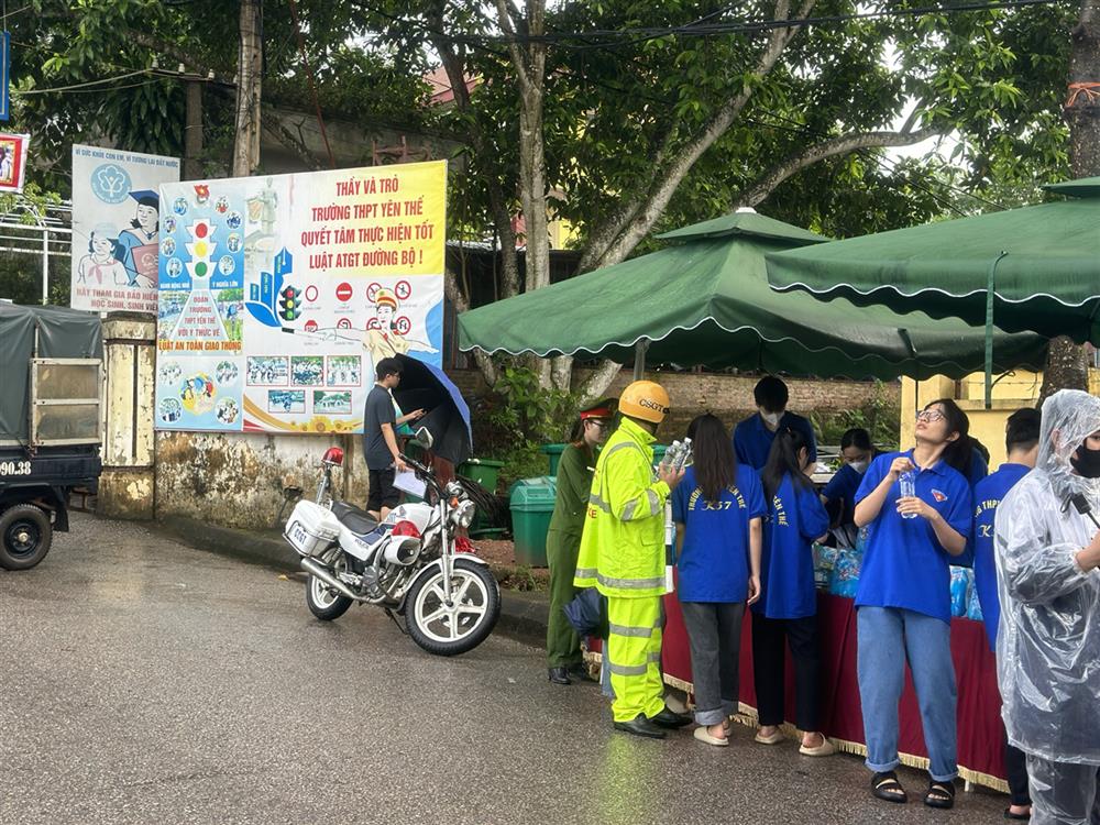 Đoàn viên thanh niên Công an huyện Yên Thế phát nước uống cho các thí sinh trước khi vào phòng thi.