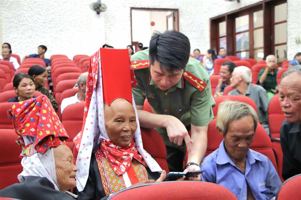 Lực lượng Công an hỗ trợ cài đặt VnID trên điện thoại cho các hộ dân.