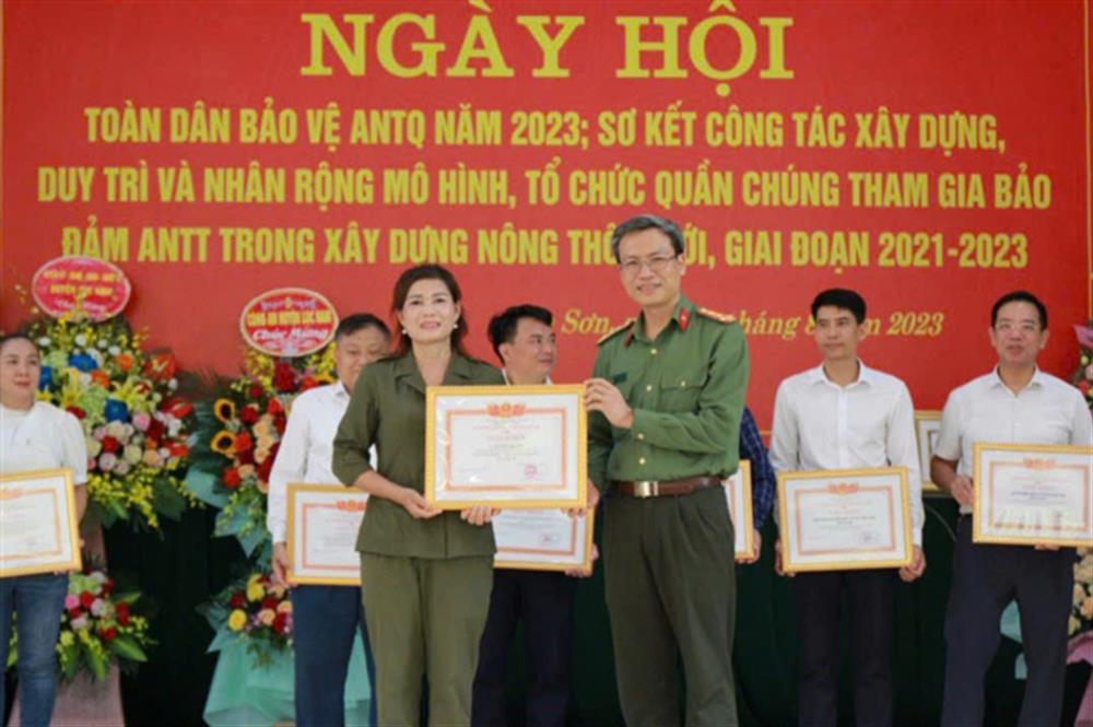 Đại tá Nguyễn Quốc Toản, Giám đốc Công an tỉnh Bắc Giang trao Giấy khen tặng bà Nguyễn Thị Nền vì đã có thành tích xuất sắc trong phong trào toàn dân bảo vệ an ninh Tổ quốc.