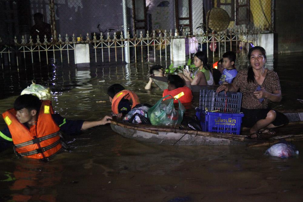 Hỗ trợ đưa người dân, trong đó có nhiều em nhỏ ra khu vực an toàn.