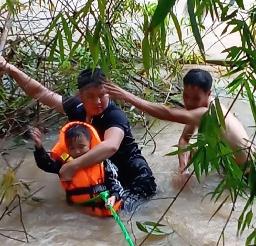 Đồng chí Đại uý Lục Văn Nguyên (áo đen) và anh Liệu Văn Quyết đưa cháu Bảo vào bờ an toàn.