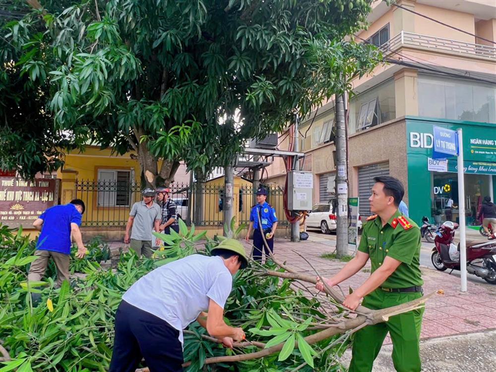 Lực lượng Công an xã hỗ trợ người dân cắt tỉa cây xanh.