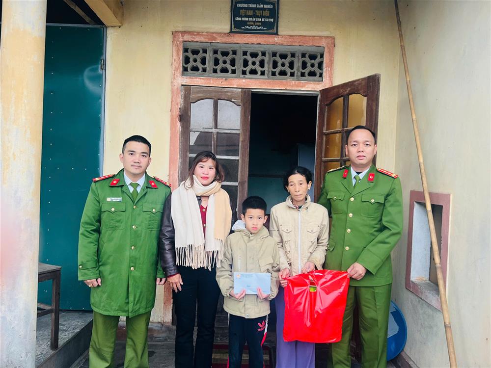 Công an xã Vĩnh Thái trao quà tặng gia đình chị Nguyễn Thị Hoa.