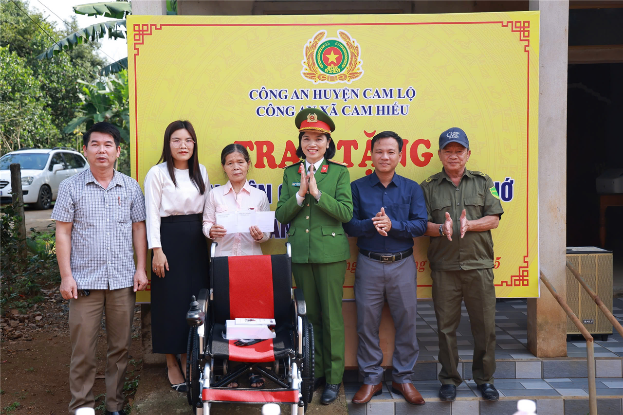 Thân nhân gia đình em Lê Thị Hoài Nhớ nhận quà tặng từ Công an xã Cam Hiếu và các nhà hảo tâm.