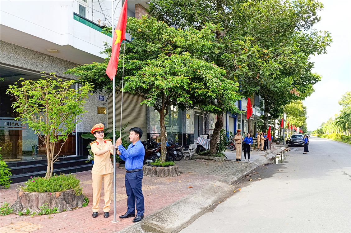 Đại biểu thực hiện nghi thức treo cờ Tổ quốc.