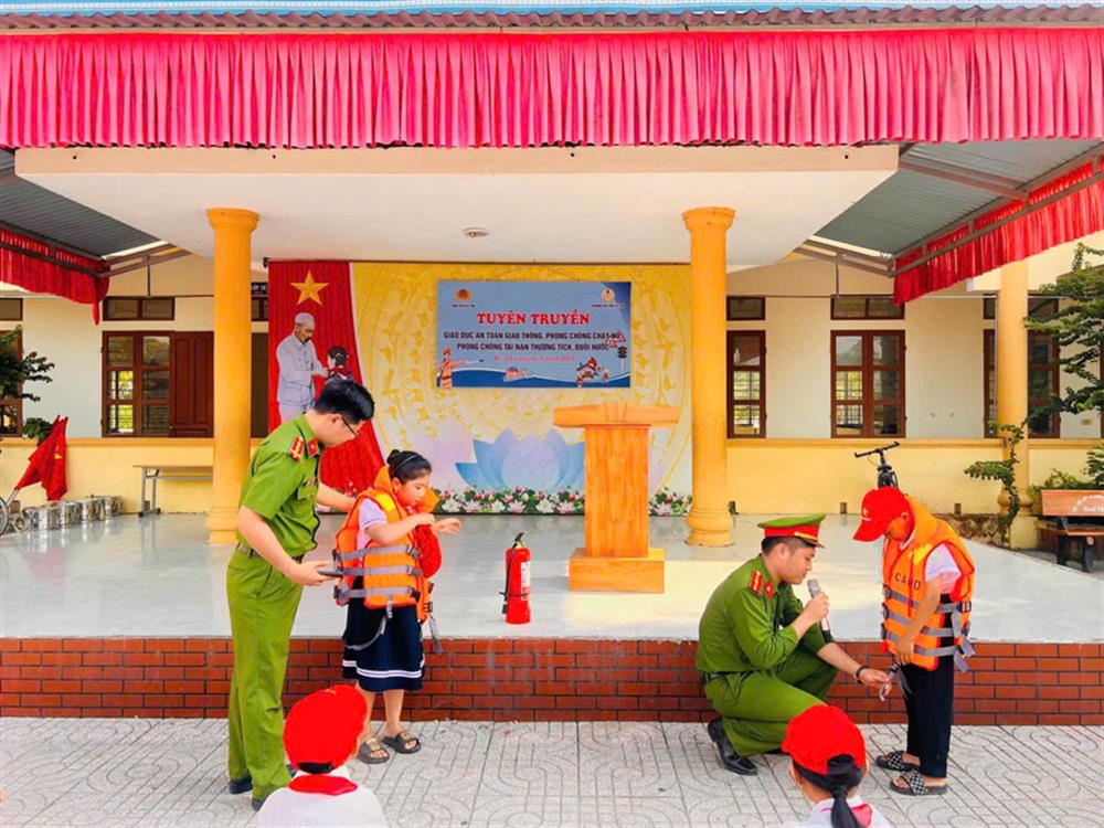 Lực lượng Công an hướng dẫn học sinh cách sử dụng áo phao đúng quy cách.