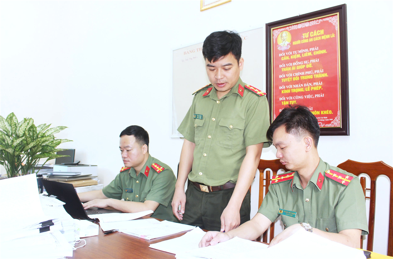 Đại úy Lê Huy Thắng (đứng giữa) thường xuyên trao đổi kinh nghiệm, kiến thức pháp luật với đồng đội phục vụ nhiệm vụ chuyên môn.