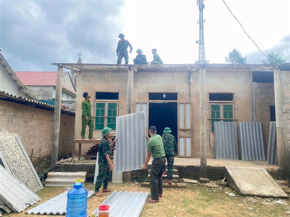 Cán bộ, chiến sĩ hỗ trợ người dân sửa chữa nhà ở do ảnh hưởng của bão số 3 (Wipha).