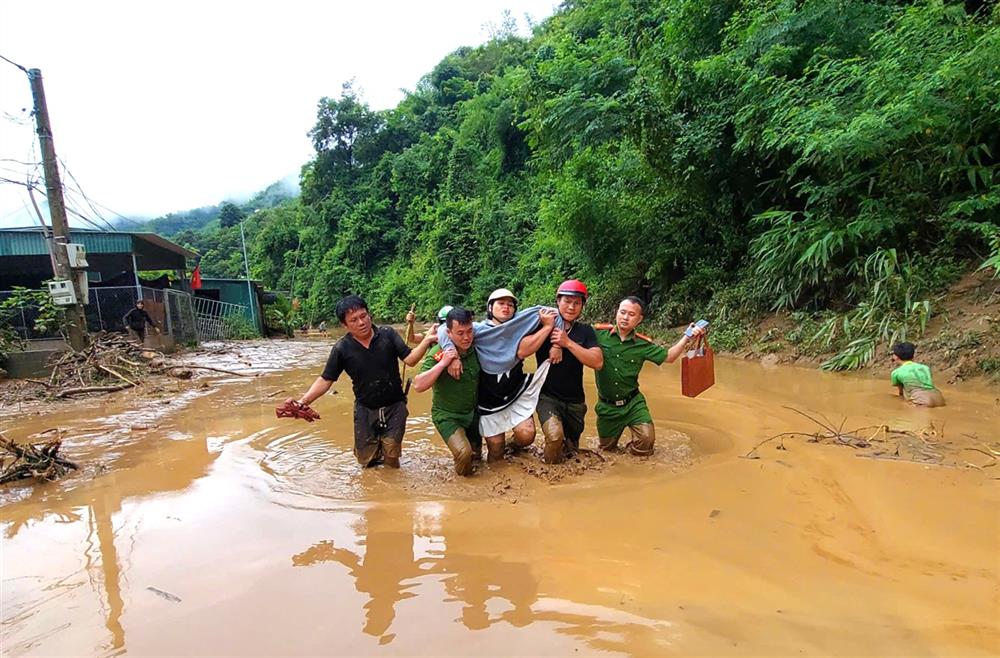 Công an xã Hữu Kiệm cùng người thân đưa chị May vượt lũ đến Trạm y tế an toàn.