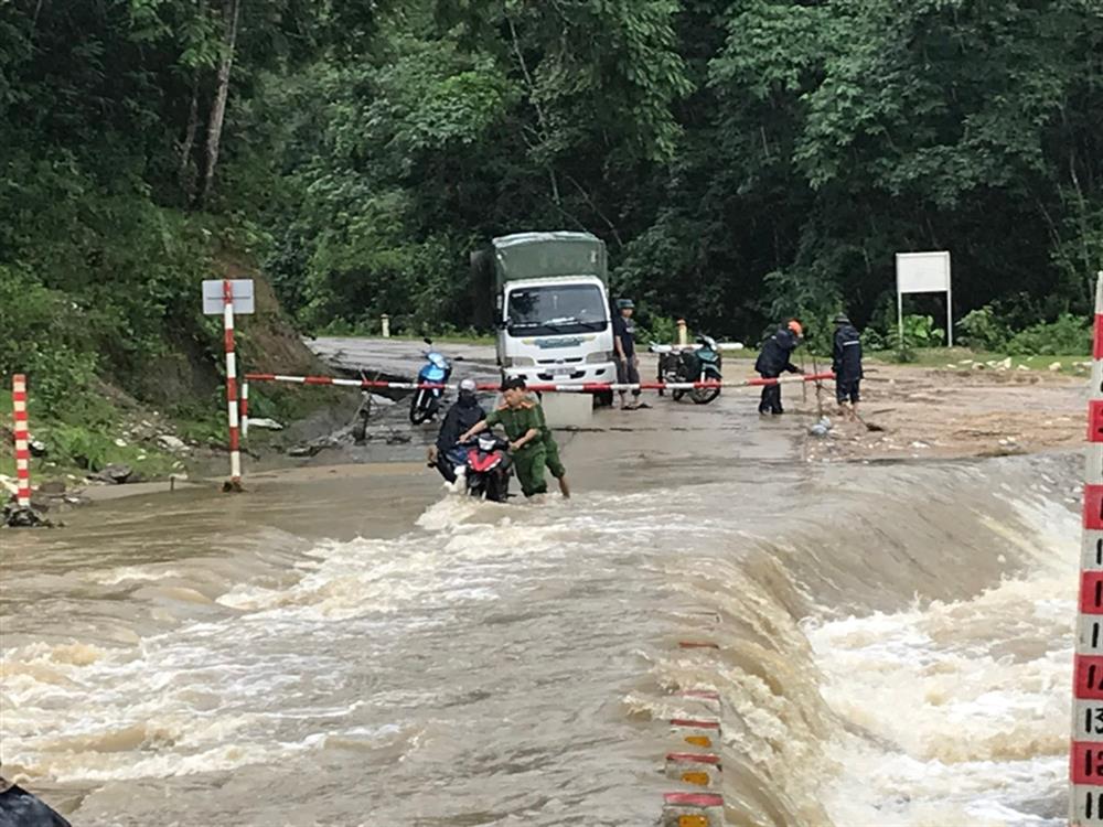 Lực lượng Công an hỗ trợ người dân di chuyển qua đập tràn.