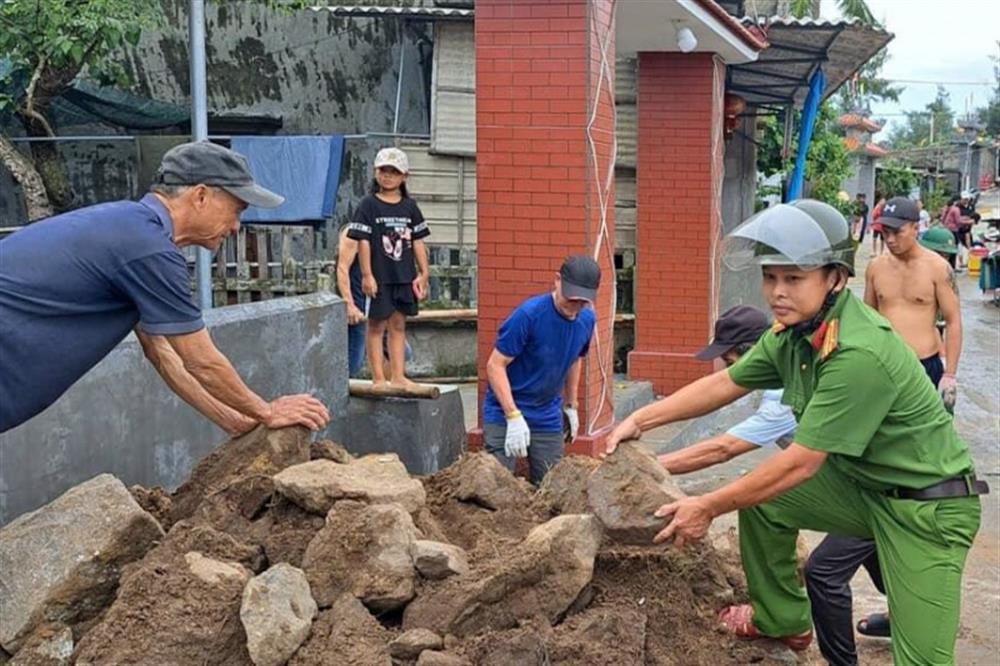 Cán bộ Công an xã Phú Diên chung tay cùng người dân khắc phục sạt lở.