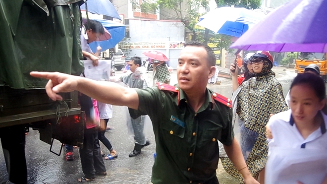 Nhiều chiến sỹ Công an dầm mình trong cơn mưa lũ giúp thí sinh lên xe đặc chủng, kịp thời đến các điểm thi đúng giờ.