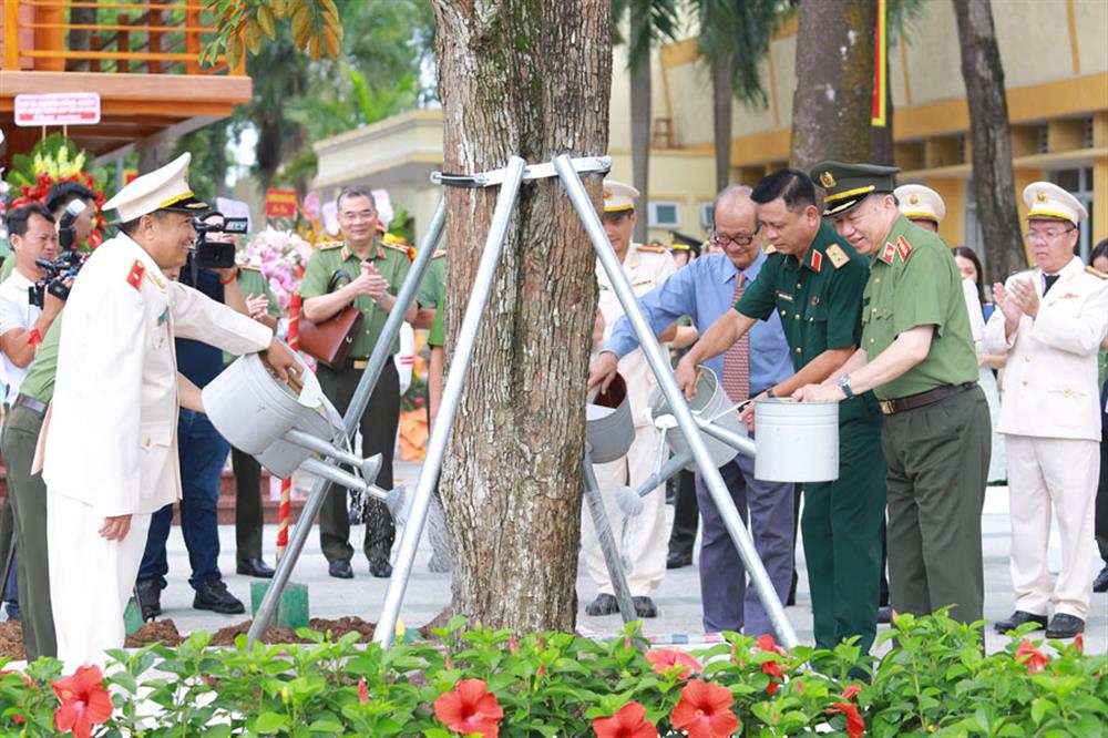 Bộ trưởng Tô Lâm cùng các đại biểu trồng cây lưu niệm tại khuôn viên trường.