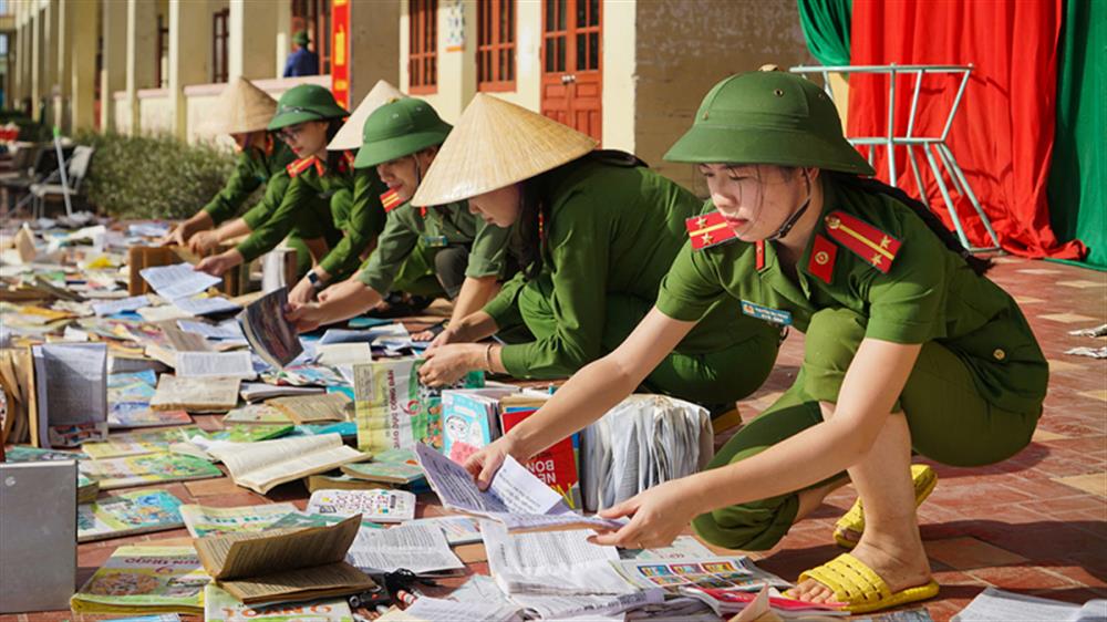 Cán bộ, chiến sĩ phơi lại sách, vở... bị ướt do mưa lũ để các em học sinh mau sớm trở lại lớp học bình thường.