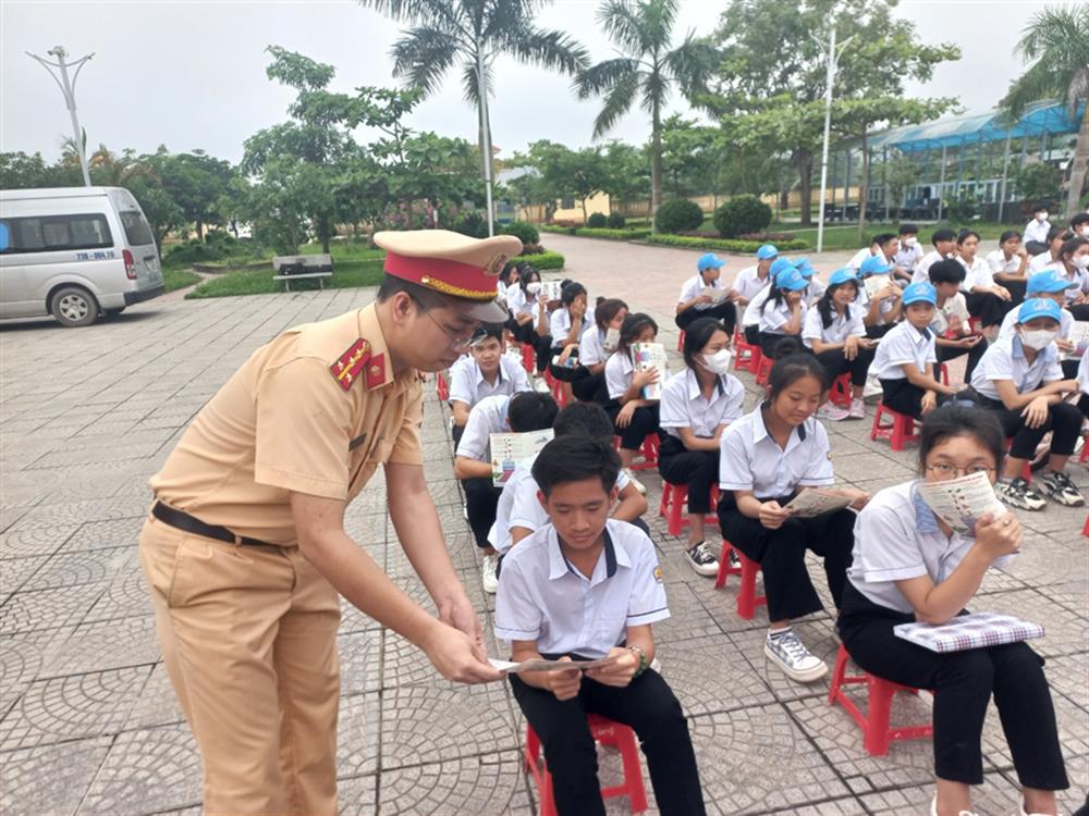 Lực lượng Cảnh sát giao thông phát tờ rơi tuyên truyền pháp luật về trật tự, an toàn giao thông tại các trường học.