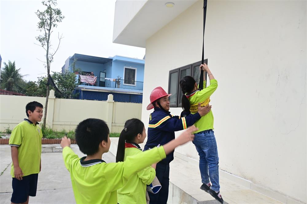 Đội Cảnh sát PCCC và CNCH hướng dẫn học sinh trải nghiệm thoát nạn bằng thang dây.