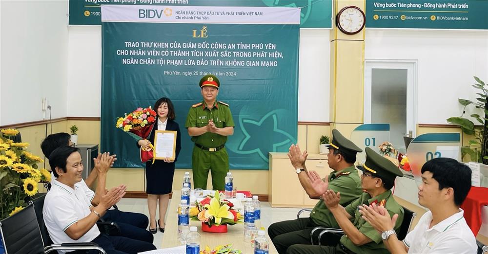 Đại tá Võ Duy Tuấn - Phó Giám đốc Công an tỉnh trao giấy khen và tiền thưởng cho chị Thanh Truyền.