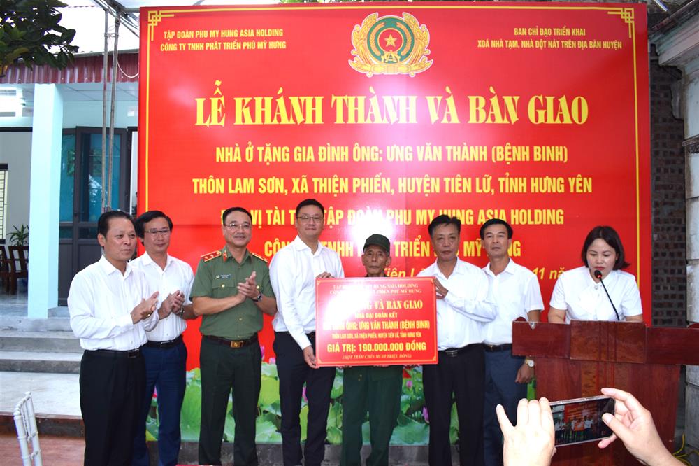 Trung tướng Phạm Thế Tùng, Thứ trưởng Bộ Công an cùng nhà tài trợ và  các đại biểu trao tiền hỗ trợ xây nhà tặng gia đình ông Ưng Văn Thành.