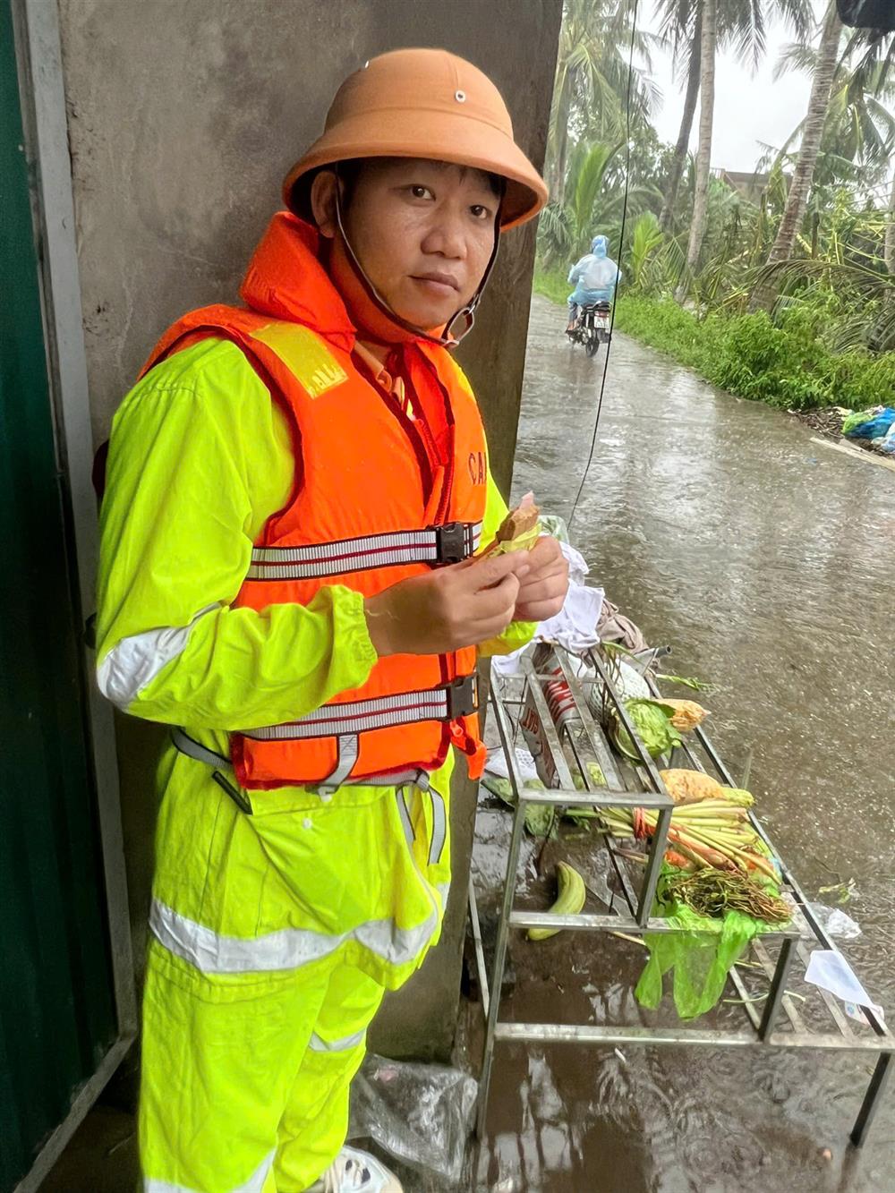 Thiếu tá Ngô Quang Vĩnh, cán bộ Đội Cảnh sát giao thông trật tự, Công an huyện Tứ Kỳ vừa ăn vừa quan sát tình hình mưa lũ.