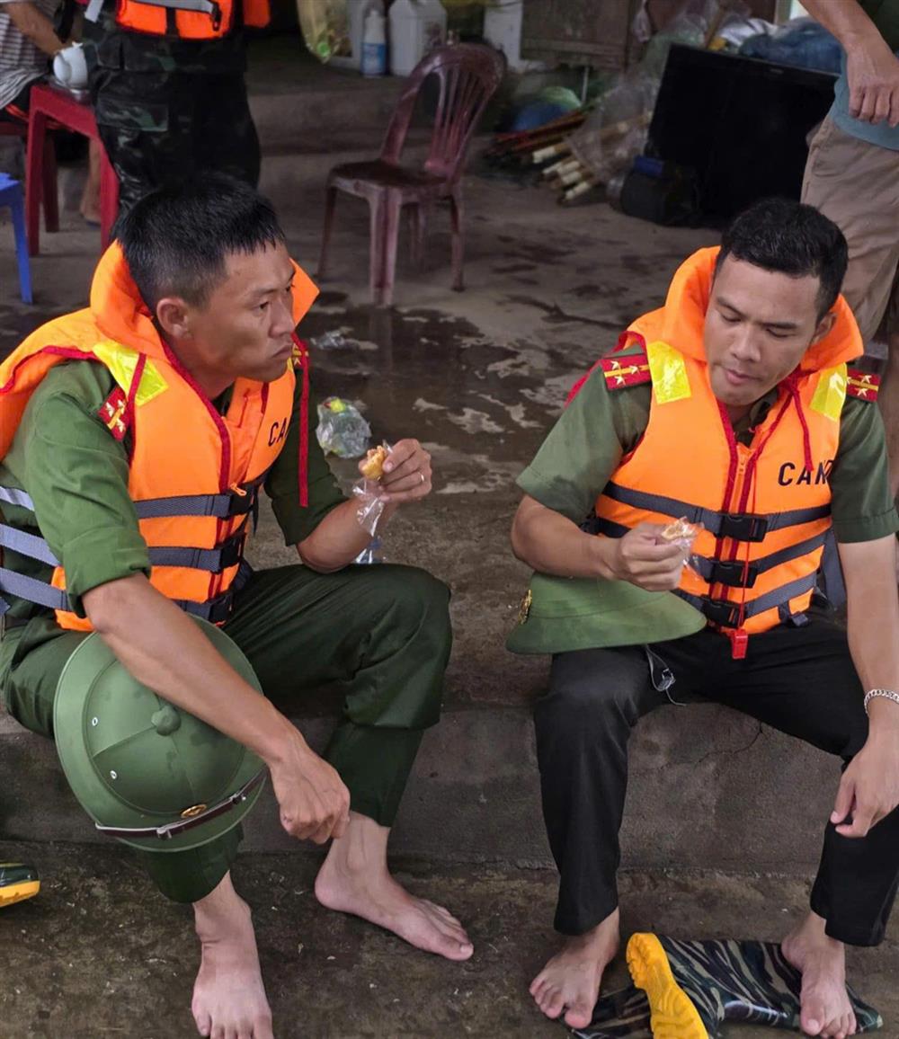 Thượng uý Phan Thanh Tuấn, cán bộ Đội Cảnh sát hình sự (trái) và Thượng uý Vương Hữu Hiến, cán bộ Đội An ninh, Công an huyện Nam Sách (phải) tranh thủ ăn vội chiếc bánh ngọt trong quá trình làm nhiệm vụ tại thôn Lấu Khê, xã Hiệp Cát, huyện Nam Sách.