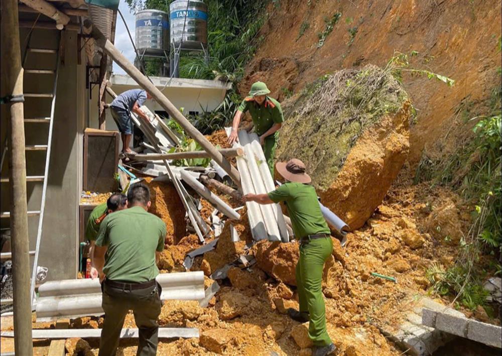 Cán bộ Công an xã Hữu Lũng hỗ trợ người dân di chuyển đồ đạc khỏi khu vực sạt lở.