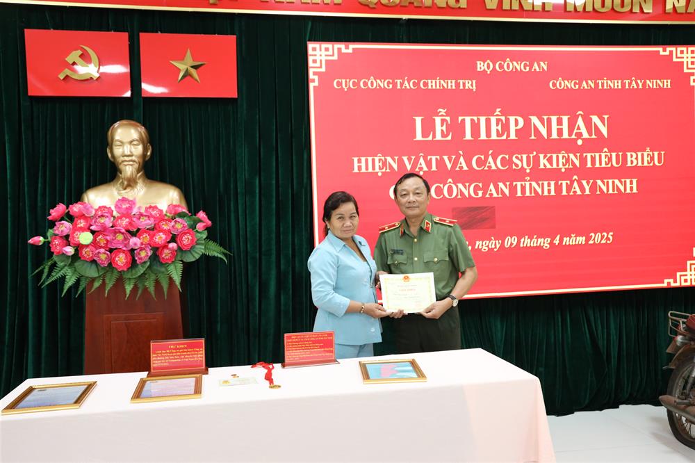 Thiếu tướng Đặng Ngọc Bách, Phó Cục trưởng Cục Công tác chính trị tiếp nhận hiện vật từ mẹ của liệt sĩ Trần Văn Lành.