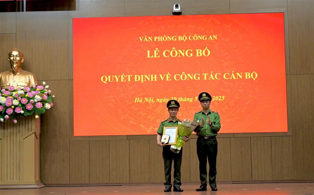 Đồng chí Thiếu tướng Nguyễn Quốc Toản, Chánh Văn phòng Bộ tặng hoa và trao quyết định cho đồng chí Thượng tá Hoàng Nguyên Ngọc.