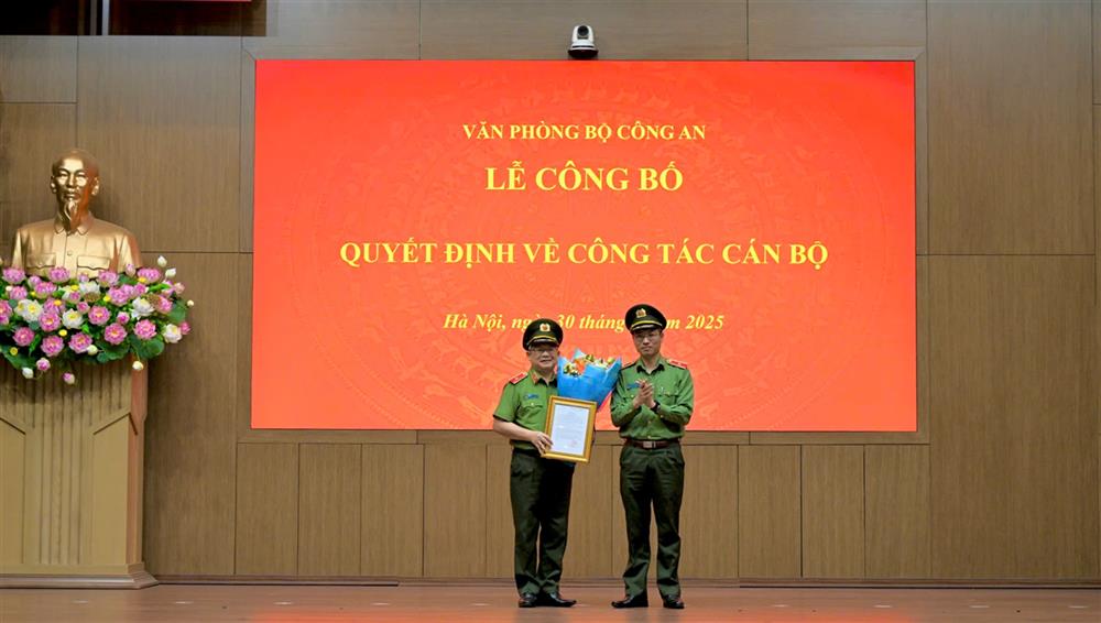 Đồng chí Thiếu tướng Nguyễn Quốc Toản, Chánh Văn phòng Bộ tặng hoa và trao quyết định cho đồng chí Thiếu tướng Hoàng Anh Tuyên.