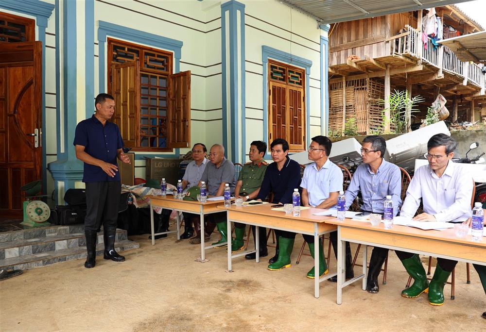 Đoàn công tác nghe báo cáo tình hình mưa lũ.