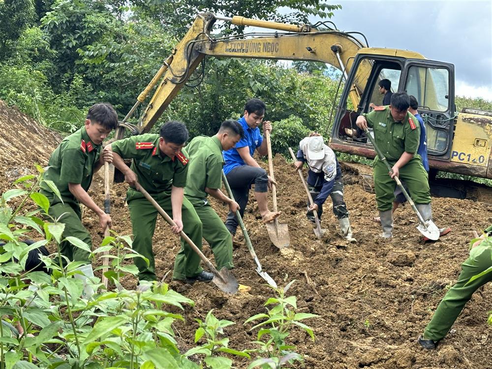 Lực lượng Công an hỗ trợ người dân bị cuốn trôi nhà do mưa lũ san ủi mặt bằng, đào móng xây nhà ở nơi an toàn.